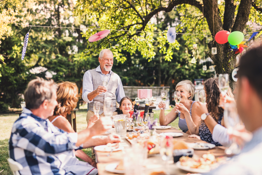 Family at a dinner table for a celebration one man is talking and people are happy