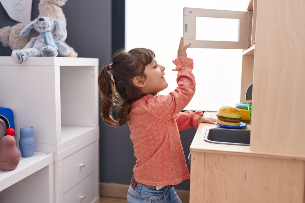 Adorable,Hispanic,Girl,Playing,With,Play,Kitchen,Standing,At,Kindergarten