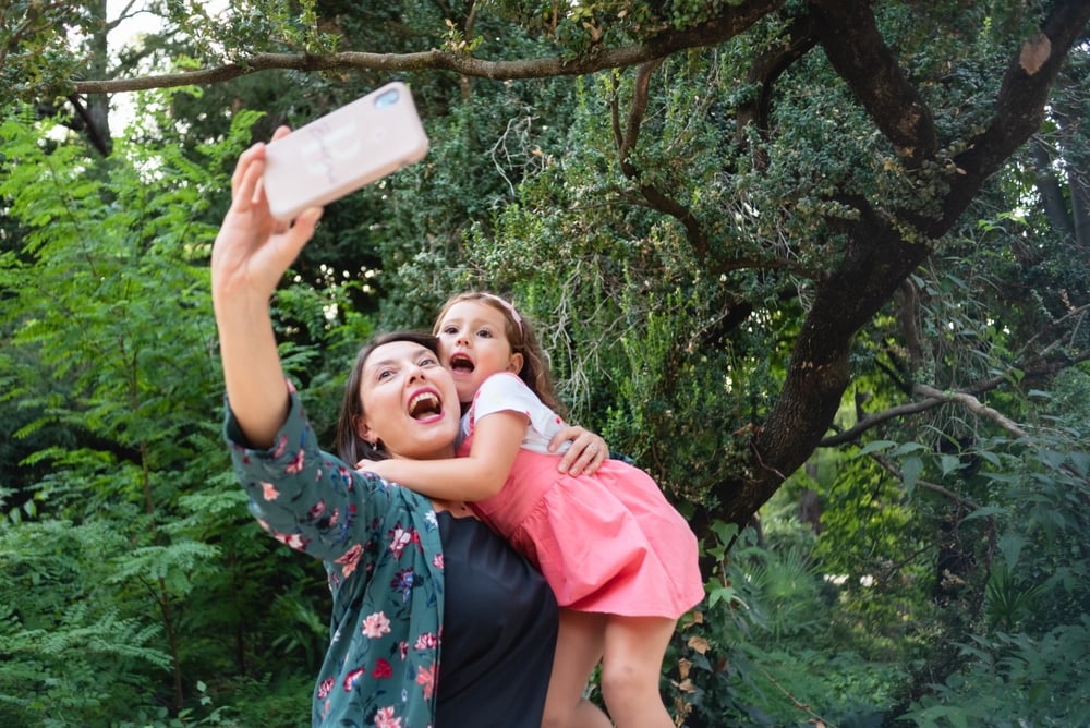 Mom taking photo with a child in her arms