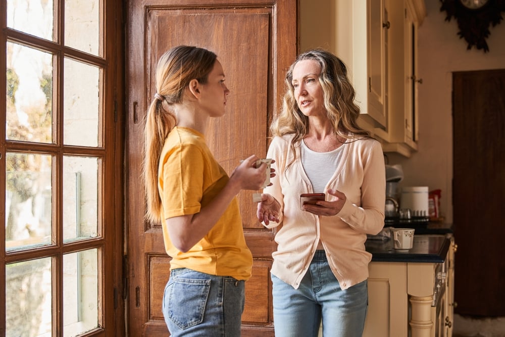 Mother,Holding,Smartphone,And,Talking,With,Serious,Face,While,Her