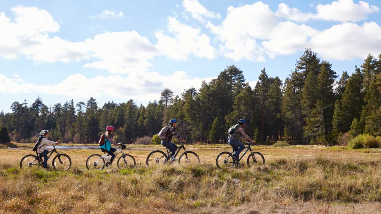 family with teens mountain biking together.