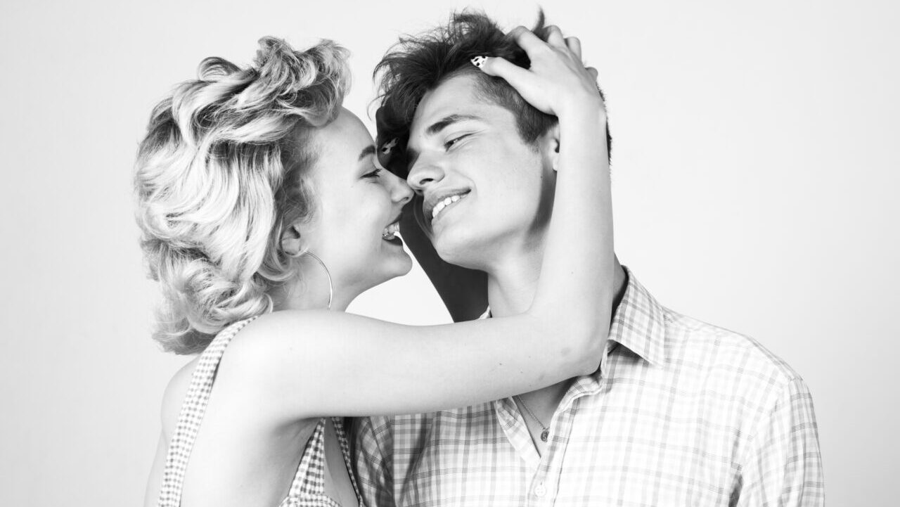 Beautiful young couple hugging and holding each other in studio. Beautiful young smiling couple in love. Love. Portrait happy loving couple. Fashion. Close up. Smile joyfully have good relationships