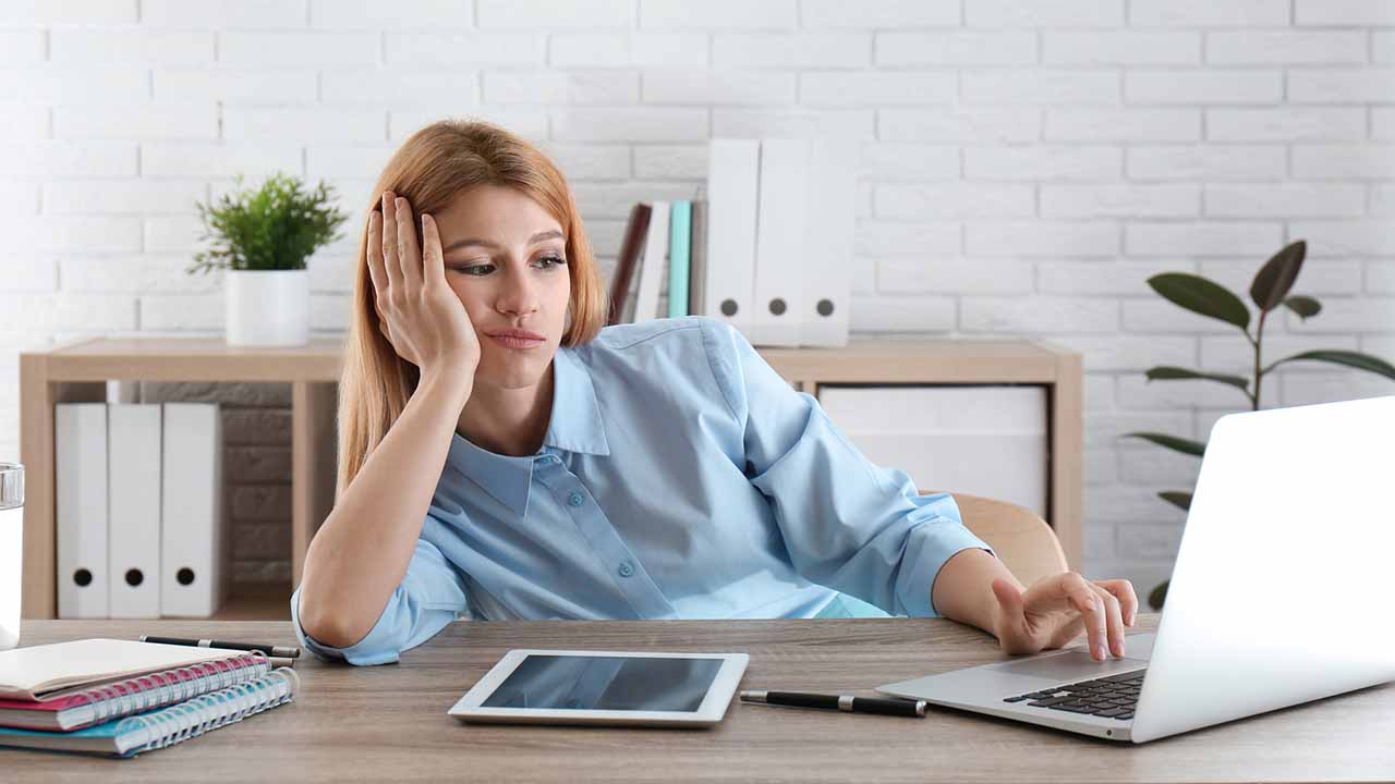 person wasting time slouched in chair looking at computer.